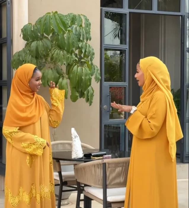 Two women in matching saffron abaya sets