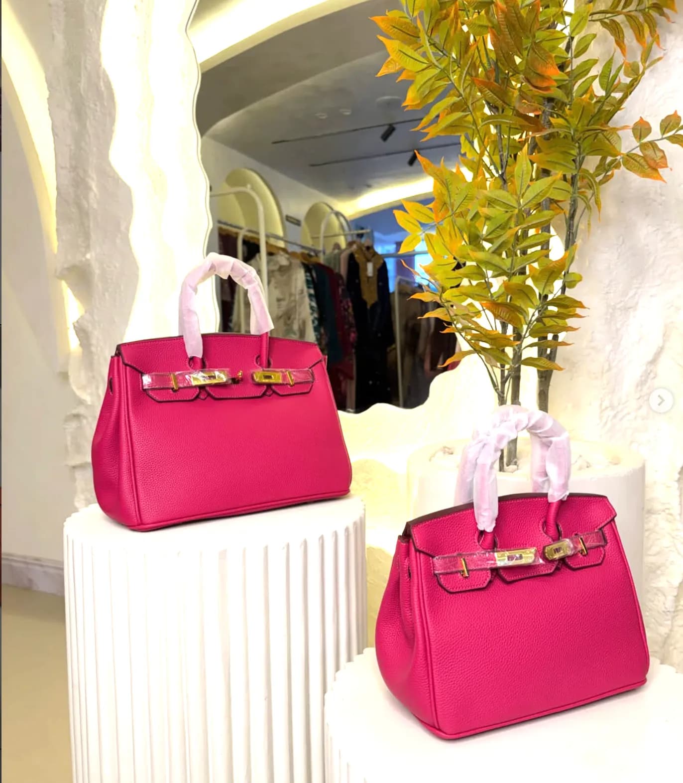Two fuchsia bags on pedestals